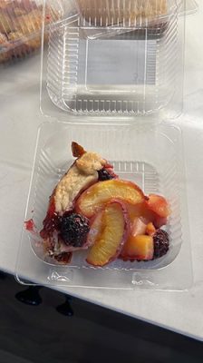 A slice of Blue Sky Productions fruit tart with peaches and blackberries